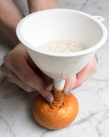 Pressing down on a balloon with funnel to expand