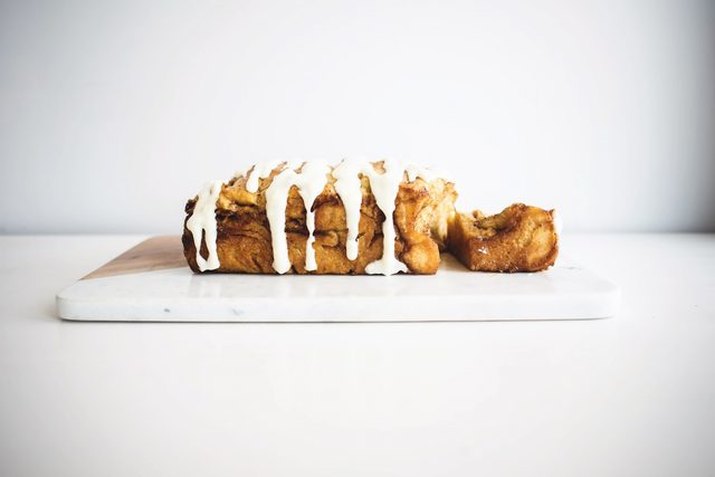 A loaf of pull-apart bread dripping with sweet glaze.